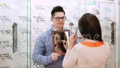 在光学商店，光学，光学零售商店，<strong>眼镜店</strong>，美女在镜子里检查她的新眼镜